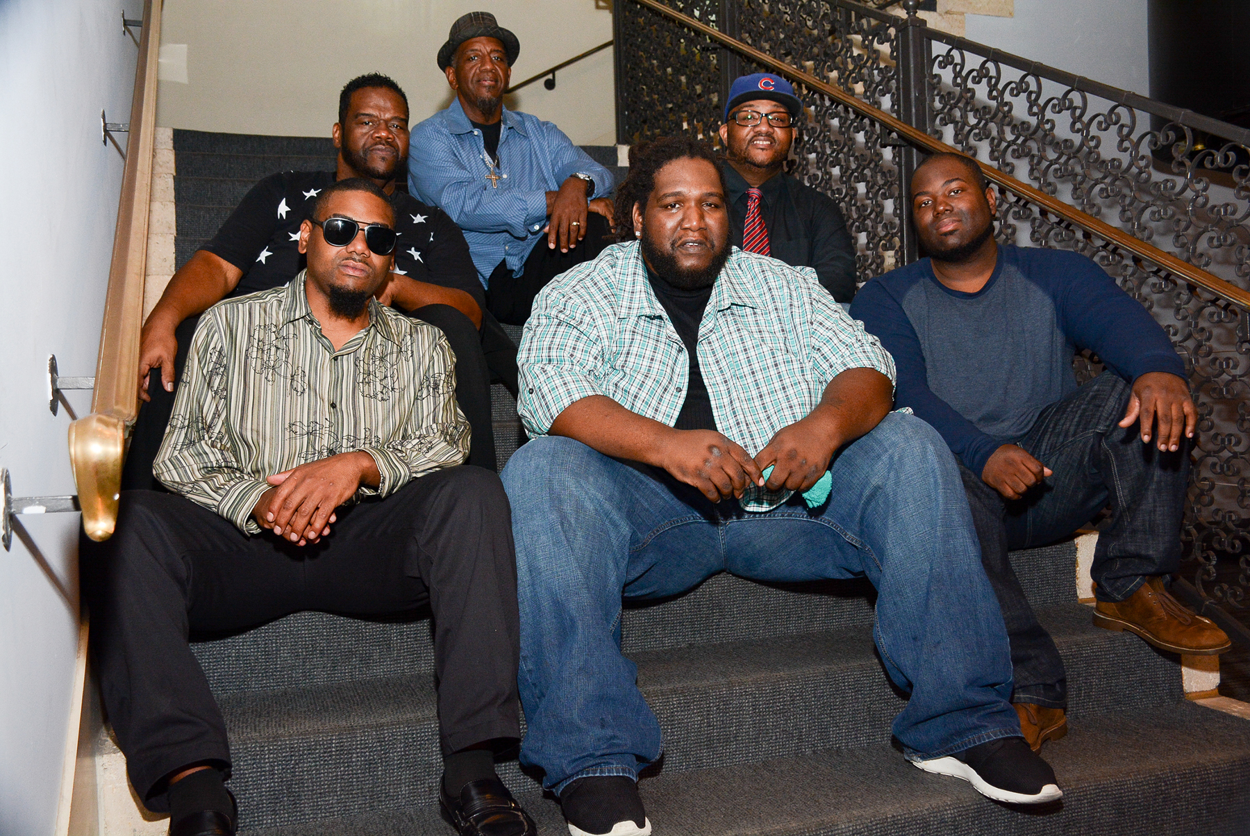 Six African American men sitting on a staircase.