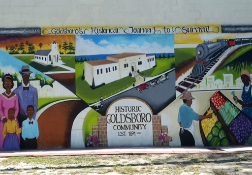Wall mural depicting scenes from Historic Goldsboro Community, to include churches, business, families and agriculture.