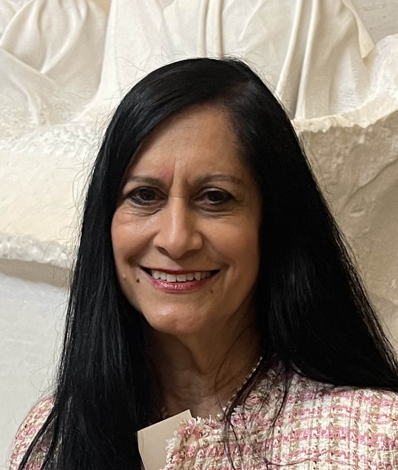 A photo of a smiling woman with long straight black hair