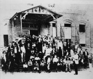 Jose Marti on steps with other men at cigar factory.