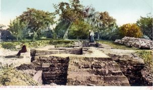 Color postcard featuring coquina foundations of an old storehouse with visitors in the background.