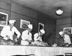 Men carving Thanksgiving turkeys.