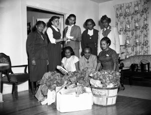 African American college women with food collected for a Thanksgiving food drive.